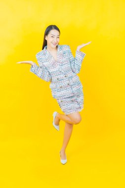 Portre güzel Asyalı kadın gülümsüyor. Renkli arka planda hareket var.