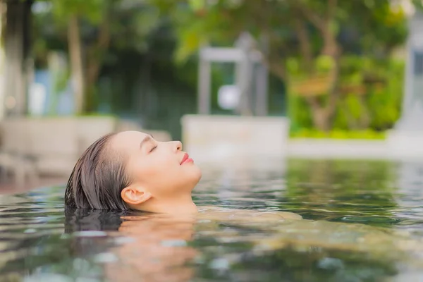 美丽动人的年轻亚洲女人度假时 在酒店度假胜地的室外游泳池边放松微笑 — 图库照片