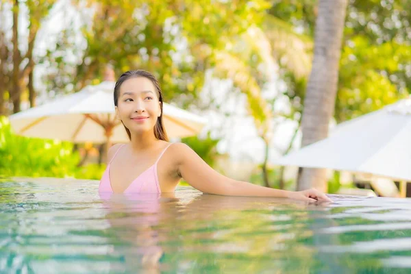 美丽动人的年轻亚洲女人在酒店的游泳池边悠闲自在地笑着 — 图库照片