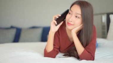 Güzel Asyalı kadının evde akıllı telefon kullandığının görüntüleri.