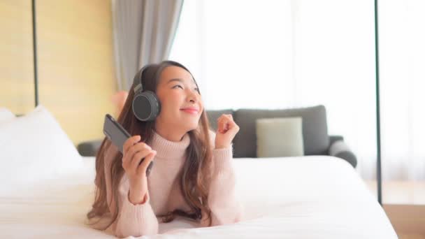 Πλάνα Από Όμορφη Ασιατική Γυναίκα Ακούγοντας Μουσική Ακουστικά Και Smartphone — Αρχείο Βίντεο