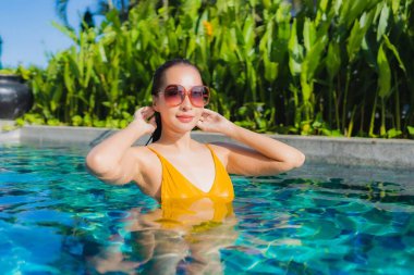 Güzel bir Asyalı kadın portresi. Rahatlayın. Keyifli bir tatil için oteldeki yüzme havuzunda mutlu bir gülümseme.
