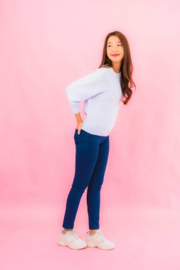 Portrait beautiful young asian woman smile with action on pink isolated background
