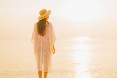 Güzel bir Asyalı kadın portresi. Rahatlayın. Güneşin batışında açık deniz okyanusunda rahatça gülümseyin.