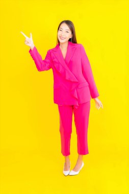 Güzel bir Asyalı kadın sarı arka planda gülümsüyor.