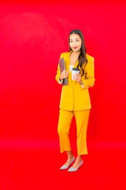Kırmızı arka planda kahve fincanı olan Asyalı güzel bir iş kadını portresi.