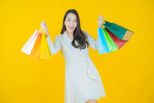 肖像画美しい若いアジアの女性の笑顔でショッピングバッグ上の色の背景 — ストック写真