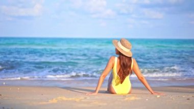 Yaz tatilinde deniz kıyısındaki Asyalı kadının görüntüleri.