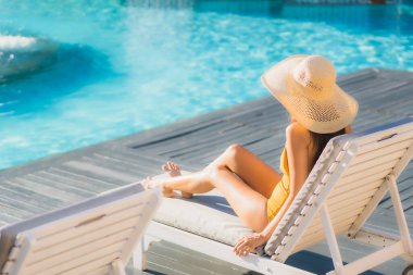 Güzel bir Asyalı kadın portresi. Mutlu bir gülümseme. Keyifli bir tatil için otel havuzunda rahatça yüzme havuzu.