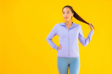 Sarı izole edilmiş arka planda spor giysili güzel Asyalı kadın portresi egzersize hazır.