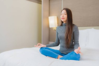 Portre güzel Asyalı kadın meditasyonu yatak odasında iç tarafta.