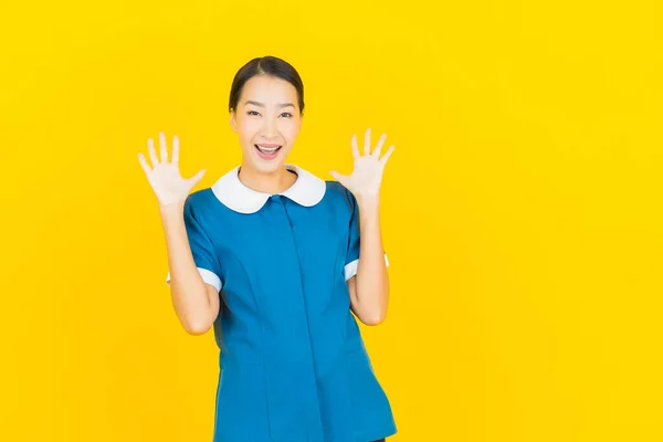Portret Piękna Młoda Azjatycka Pokojówka Pokojówka Uśmiech Akcji Żółtym Tle — Zdjęcie stockowe