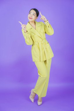 Portre güzel Asyalı kadın gülümsüyor. Renkli arka planda hareket var.