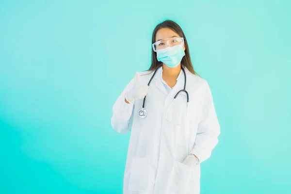 Portrait beautiful young asian doctor woman with mask work at clinic or hospital on blue isolated background