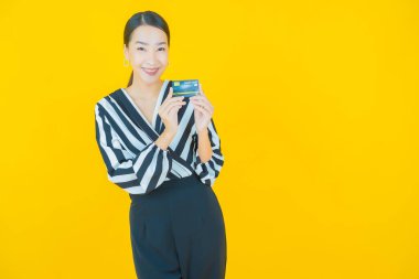 Güzel bir Asyalı kadının portresi. Renkli kredi kartıyla gülüyor.