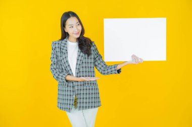 Renkli arka planda boş beyaz ilan panosu olan güzel Asyalı kadın portresi