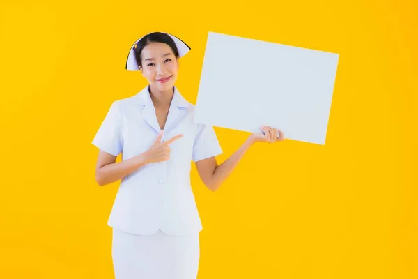 年轻美丽的亚裔妇女 泰国人护士 空荡荡的白板 在孤立的黄色背景下 在诊所或医院工作 — 图库照片