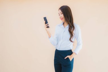 Akıllı cep telefonu ve kahve fincanı olan güzel bir iş kadını portresi.