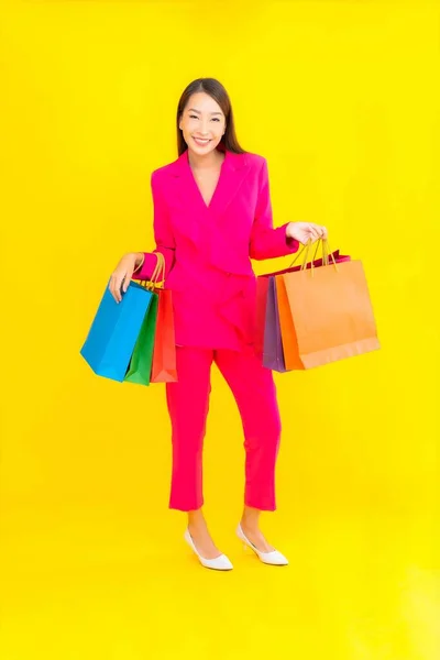 肖像画美しい若いアジアの女性とともにカラフルなショッピングバッグ上の色隔離された背景 — ストック写真