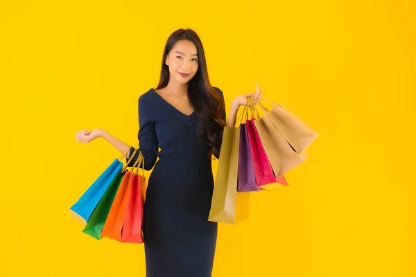 노란색외진 배경에 쇼핑백을 아름다운 아시아 여자의 — 스톡 사진
