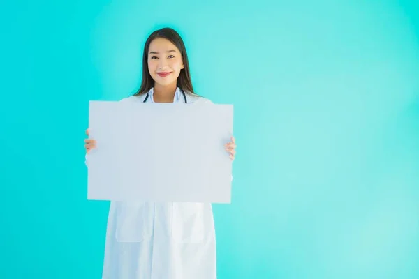 肖像画美しいです若いですアジアの医師女性とともに空のカード看板バナー上の青隔離された背景 — ストック写真