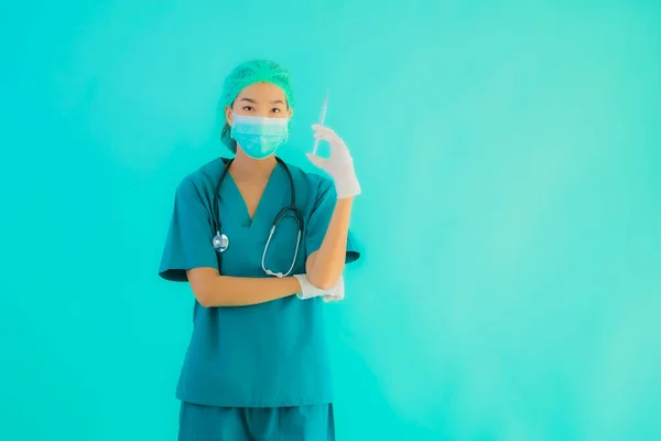 ポートレート美しい若いアジアの医師の女性は 青い隔離された背景にCoid19またはコロナウイルスから保護するための注射器ワクチンとマスクを着用 — ストック写真