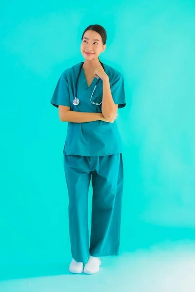 Portrait beautiful young asian doctor woman smile with many action on blue isolated background