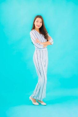 Asyalı güzel bir kadının portresi mavi izole edilmiş arka planda gülümsüyor.