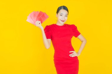 Renk arka planında kırmızı zarflı güzel Asyalı kadın portresi.