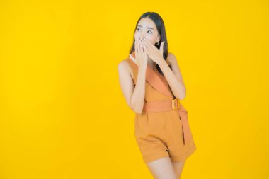 Portre güzel Asyalı kadın gülümsüyor. Renkli arka planda hareket var.