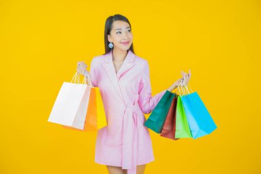 Portre güzel Asyalı kadın tebessümü ile renk arka planında alışveriş torbası