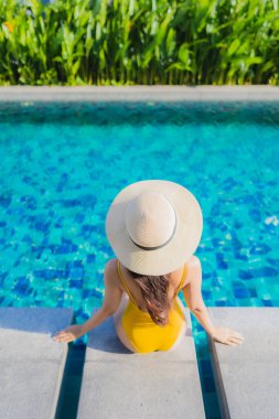 Güzel bir Asyalı kadın portresi. Rahatlayın. Keyifli bir tatil için oteldeki yüzme havuzunda mutlu bir gülümseme.