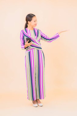 Güzel bir Asyalı kadın portresi izole edilmiş arka planda akıllı cep telefonu kullanır.