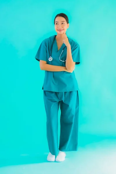 ポートレート美しいです若いですアジアの医師女性笑顔ともに多くのアクション上の青隔離された背景 — ストック写真