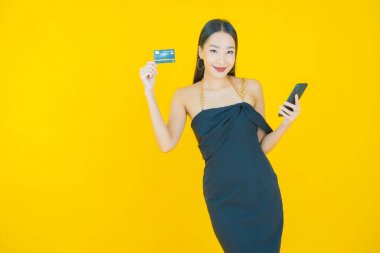 Güzel bir Asyalı kadının portresi. Renkli kredi kartıyla gülüyor.