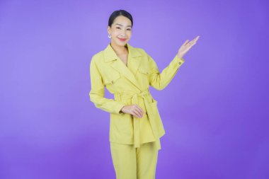 Portre güzel Asyalı kadın gülümsüyor. Renkli arka planda hareket var.