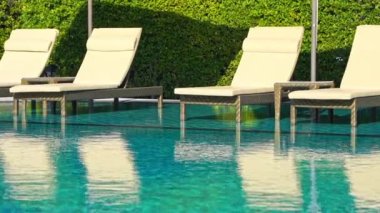 Otelde tatil için yüzme havuzunun etrafında güneşli yataklar.