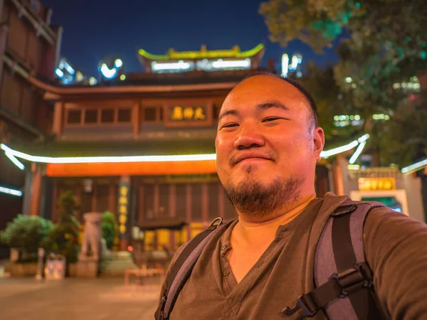 Portrail photo of asian man traveler in Huogongdian Food garden entrance Gate in Changsha city China.changsha is the capital and most populous city of Hunan province in china