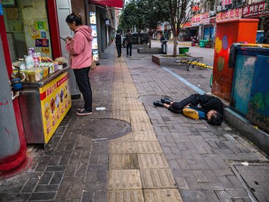 Changsha/China-18 October 2018:Unacquainted  Drunken Sleeping on Street in the morning at Changsha city hunan China.Taiping old street one of landmark in changsha city