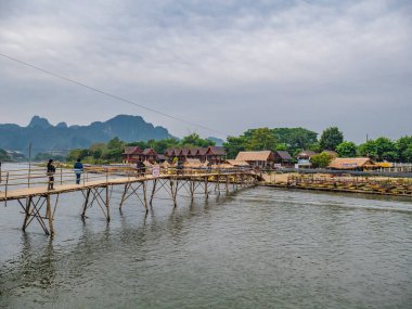 Vangvieng/lao-5 Dec 2017:Unacquainted People on the wooden bridge with beautiful view of Nam Song River in vangvieng Lao.Vangvieng City The famous holiday destination town in Lao.