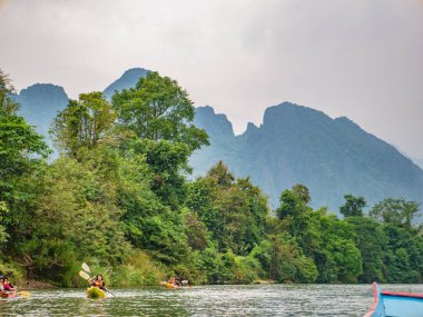 Vangvieng/lao-10 Dec 2017::Unacquainted tourist kayaking on namsong river at vangvieng city Laos.Vangvieng City The famous holiday destination town in Lao.