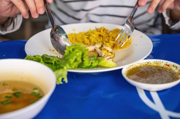 10代の若者はステンレスを使用していますかわいい食べるビリヤニチキンライス野菜のソースとスープとトップストリートフードレストラン — ストック写真