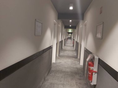 Beyaz ve gri duvarlı otel koridoru