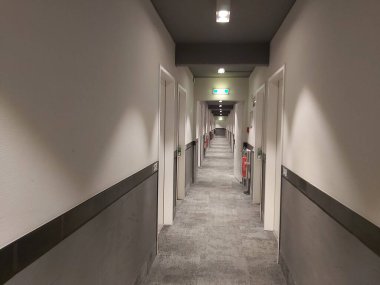 Beyaz ve gri duvarlı otel koridoru