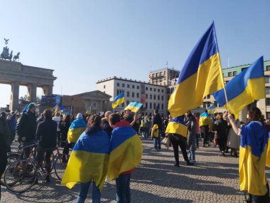 20 / 03 / 2022 BERLIN, GERMANY: Ukrayna halkını desteklemek için Brandenburg Kapısı önünde toplanan insanlar