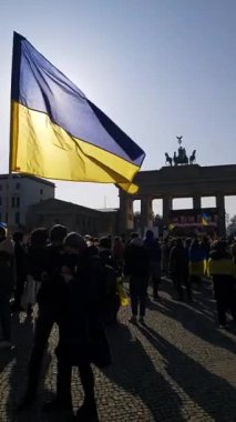20 / 03 / 2022 BERLIN, GERMANY: Ukrayna halkını desteklemek için Brandenburg Kapısı önünde toplanan insanlar