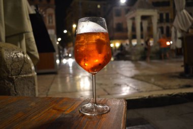 Verona Meydanı 'nın arka planında bir bardak Spritz kuyruk.