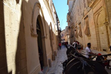 people on the streets of city. Maltese architecture buildings and houses in city
