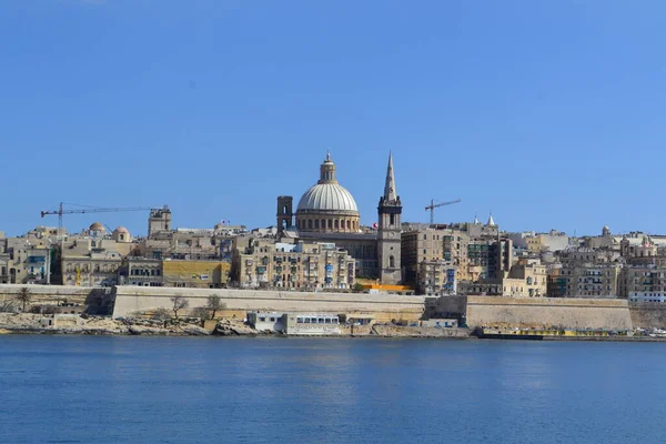 View from above of the golden domes of churches and roofs with church of Our Lady of Mount Carmel and St. Paul's Anglican Pro-Cathedral, Valletta, Capital city of Malta