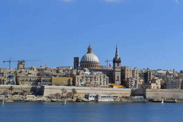 View from above of the golden domes of churches and roofs with church of Our Lady of Mount Carmel and St. Paul's Anglican Pro-Cathedral, Valletta, Capital city of Malta